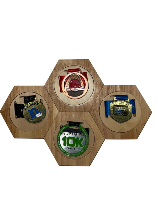 Hexagonal wooden display with four medals on a white background